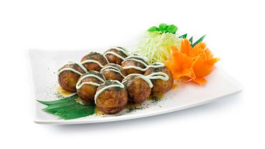 Takoyaki içeride, Tako Octopus pirzolasıyla Japon yemeği kırma stili üzerine Norveç yosunu ve tatlı sos, oyulmuş havuç ve lahana yan görüntüsü.