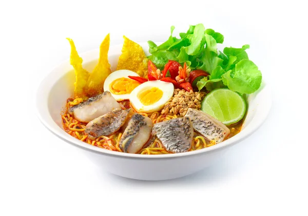 Egg Noodles with Asian Sea bass fish or Snapper fish in Spicy Soup (Tom Yum) coconut milk and Thai herb Thai Food fusion style decorate with Fried Crispy Wonton and carved chili side view