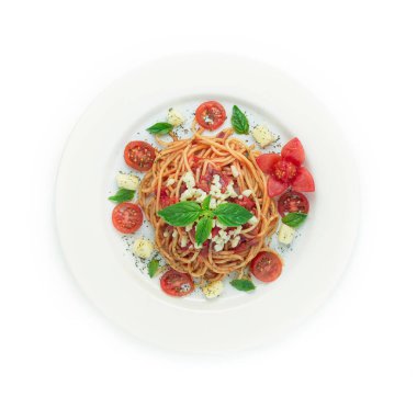 Domates soslu spagetti İtalyan geleneksel yemek stili taze Mozzarella peynirli pirzola, otlar, domates, nane ve oyulmuş domates çiçeği biçimli üst görünüm