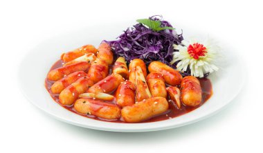 Tteokbokki Rice Cake çubuğu ve Kochujung soslu pırasa Tatlı Kore Sıcak ve Baharatlı Yemek Tabağı oyulmuş pırasa çiçek şekilli ve Mor Lahana Dilimlenmiş Yapraklı Tayland bitkisi