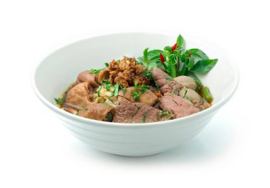 Pirinç erişteli biftek çorbası, ciğer, bağırsak ağır ateşte pişmiş ve sarımsaklı biftek köftesi ve Kokulu Ot Bahar soğanı ve Basil Thai bitkileri süslüyor. Tayland Kayığı Erişte Tarzı yan görünümü