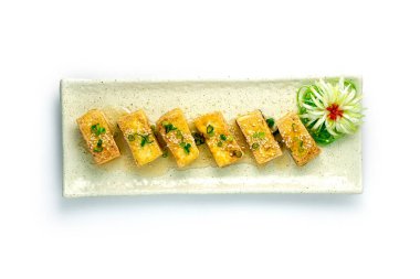 Bol yağda kızartılmış soya soslu susam ve taze soğanlı pirzola Asya aperatifi oyulmuş Pırasalı Japonya soğanı çiçek şeklinde üst görünüm şeklinde paketliyor.