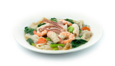 Beyaz tabakta soslu kızarmış erişte, karides, kalamar ve kalamar sosu. Çin Gıda Asya tarzı dekore edilmiş oyulmuş havuç çiçekli kenar manzara