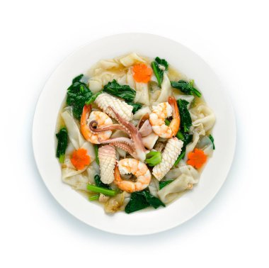 Beyaz tabakta soslu kızarmış erişte, karides, kalamar ve kalamar sosu. Çin Gıda Asya tarzı dekore edilmiş havuç çiçekli üst görünüm