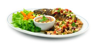 Kızarmış balık yılanbaşı ve acılı balık salatası karışık otlar Tayland yemeği oyulmuş salatalık ve sebze sosuyla süslenmiş Maincorse yemeği.