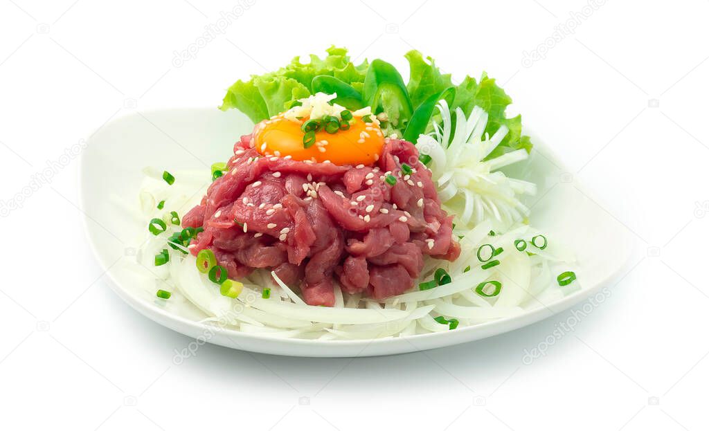 Yuk Hoe Korean raw Beef Tartar with Sesame oil,soy sauce,sugar,garlic,white wine mixed ontop Egg Yolk Sprinkle with Spring Onions and garlic decorate with carved Leek,Chili and vegetable sideview