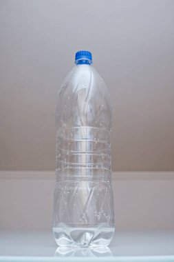 Plastik şeffaf şişe ve az miktarda su.