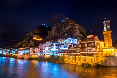 Amasya, Türkiye - Ağustos 2017: Eski Osmanlı evleri ve Amasya 'daki Yesilirmak Nehri' nin yansımalı manzaralı Saat Kulesi. Amasya Türkiye 'de daha popüler bir turizm beldesi.