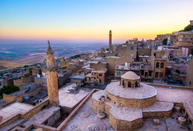 Mardin manzarası bulutlu Türkiye 'nin güzel günbatımı. Minareler Mardin 'in en iyi turistik beldesidir..