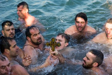 İstanbul, Türkiye - 6 Ocak 2018. Epifani töreninde insanlar ve ahşap haç suyu kutsamak için toplandı. Bu tören Fener 'de (Balat) her yıl Altın Boynuz' dan (Halic) Epifani 'yi simgeler.)