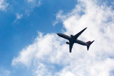 Mavi gökyüzünde bir uçak ve güzel bulutlar. Harika seyahat fotoğrafı..