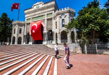 İSTANBUL, TURKEY - 6 Ağustos 2016: İstanbul Üniversitesi 'nin Beyazit Meydanı, İstanbul, Türkiye' de büyük Türk bayrağı taşıyan kemerli tarihi geçidi