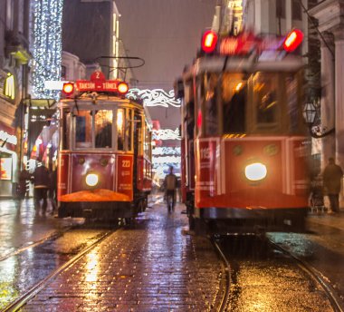 İSTANBUL, TURKEY - 3 Ocak: Taksim Istiklal Caddesi, 3 Ocak gecesi. 2016, Beyoğlu, Türkiye. İstanbul 'un en iyi caddesi orada yağmur ve kar var. Sokakta birlikte iki tramvay var..