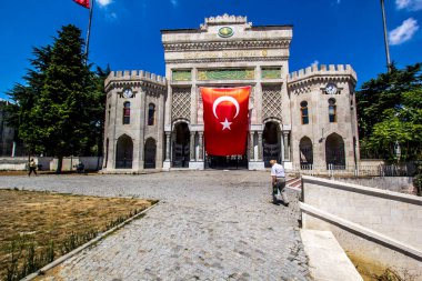 İSTANBUL, TURKEY - 6 Ağustos 2016: İstanbul Üniversitesi 'nin Beyazit Meydanı, İstanbul, Türkiye' de büyük Türk bayrağı taşıyan kemerli tarihi geçidi