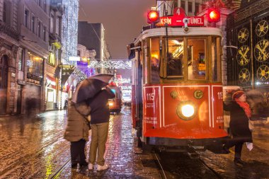 İSTANBUL, TURKEY - 3 Ocak: Taksim Istiklal Caddesi, 3 Ocak gecesi. 2016, Beyoğlu, Türkiye. İstanbul 'un en iyi caddesi orada yağmur ve kar var. Sokakta birlikte iki tramvay var..