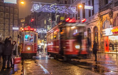 İSTANBUL, TURKEY - 3 Ocak: Taksim Istiklal Caddesi, 3 Ocak gecesi. 2016, Beyoğlu, Türkiye. İstanbul 'un en iyi caddesi orada yağmur ve kar var. Sokakta birlikte iki tramvay var..