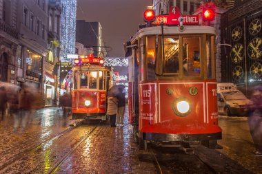 İSTANBUL, TURKEY - 3 Ocak: Taksim Istiklal Caddesi, 3 Ocak gecesi. 2016, Beyoğlu, Türkiye. İstanbul 'un en iyi caddesi orada yağmur ve kar var. Sokakta birlikte iki tramvay var..