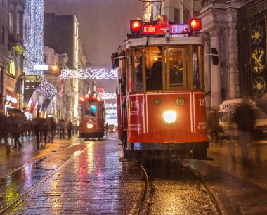 İSTANBUL, TURKEY - 3 Ocak: Taksim Istiklal Caddesi, 3 Ocak gecesi. 2016, Beyoğlu, Türkiye. İstanbul 'un en iyi caddesi orada yağmur ve kar var. Sokakta birlikte iki tramvay var..