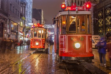 İSTANBUL, TURKEY - 3 Ocak: Taksim Istiklal Caddesi, 3 Ocak gecesi. 2016, Beyoğlu, Türkiye. İstanbul 'un en iyi caddesi orada yağmur ve kar var. Sokakta birlikte iki tramvay var..