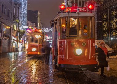 İSTANBUL, TURKEY - 3 Ocak: Taksim Istiklal Caddesi, 3 Ocak gecesi. 2016, Beyoğlu, Türkiye. İstanbul 'un en iyi caddesi orada yağmur ve kar var. Sokakta birlikte iki tramvay var..