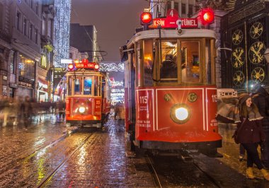 İSTANBUL, TURKEY - 3 Ocak: Taksim Istiklal Caddesi, 3 Ocak gecesi. 2016, Beyoğlu, Türkiye. İstanbul 'un en iyi caddesi orada yağmur ve kar var. Sokakta birlikte iki tramvay var..