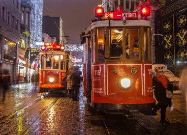 İSTANBUL, TURKEY - 3 Ocak: Taksim Istiklal Caddesi, 3 Ocak gecesi. 2016, Beyoğlu, Türkiye. İstanbul 'un en iyi caddesi orada yağmur ve kar var. Sokakta birlikte iki tramvay var..