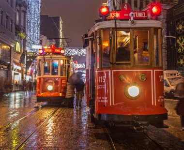 İSTANBUL, TURKEY - 3 Ocak: Taksim Istiklal Caddesi, 3 Ocak gecesi. 2016, Beyoğlu, Türkiye. İstanbul 'un en iyi caddesi orada yağmur ve kar var. Sokakta birlikte iki tramvay var..