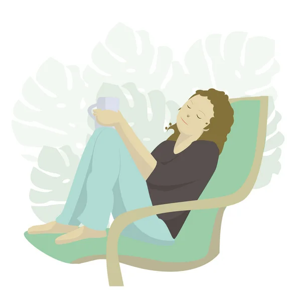 Koltuğunda oturan bir kız elinde bir kupa tutuyor.