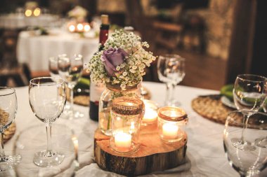 Çiçekler ve mumlarla süslenmiş düğün masası.