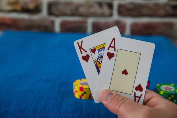 Mavi arkaplanda kart ve çiplerle poker oyunu