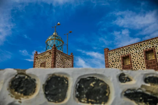 Gökyüzü ve bulutları olan eski deniz feneri