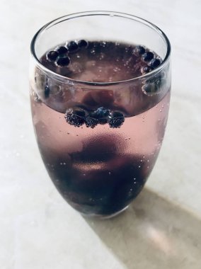 Ardıç meyvesi ve buzlu bir bardak cin tonik.