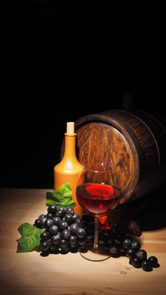 Bicchiere di vino rosso e botte sul tavolo di legno — Foto Stock
