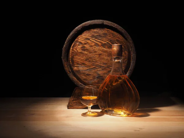 Verre de cognac avec tonneau sur fond en bois — Photo