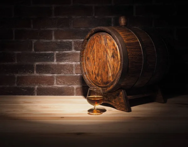 Glas cognac met vat op houten tafel — Stockfoto