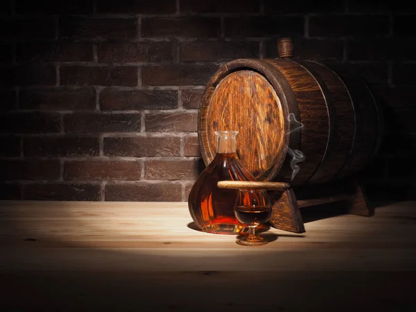 Glas Cognac mit Fass auf Holztisch — Stockfoto