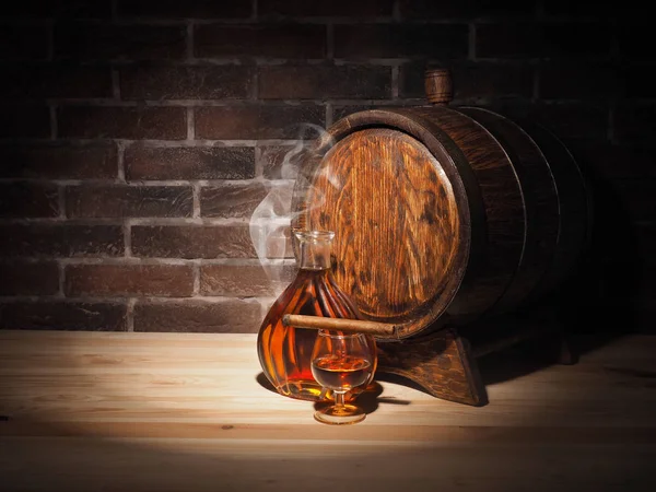 Glas Cognac mit Fass auf Holztisch — Stockfoto