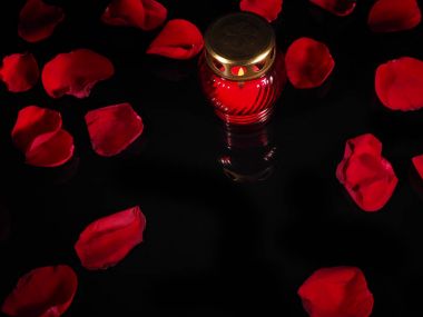 Kırmızı cam şamdan içinde yanan mum