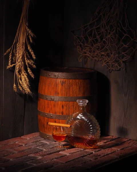 Glas cognac met vat in gezellige kelder — Stockfoto