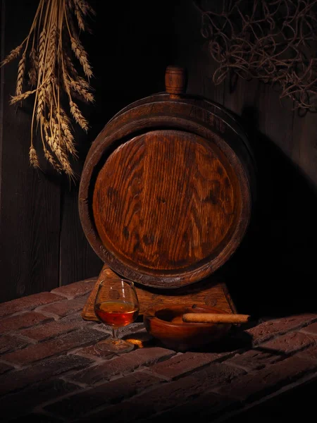 Glas Cognac mit Fass im gemütlichen Keller — Stockfoto