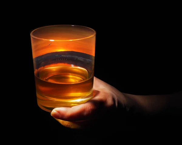 Glass of whiskey with an evening view of the city inside — Stock Photo, Image