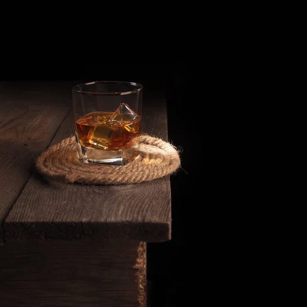 Glass of whiskey on rustic table.black background — Stock Photo, Image