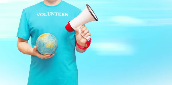 一个穿着蓝色T恤的男人和题词志愿者世界各地志愿服务的概念 — 图库照片