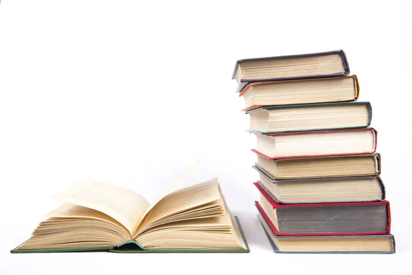 Stack of books in color covers next to the open book — Stock Photo, Image