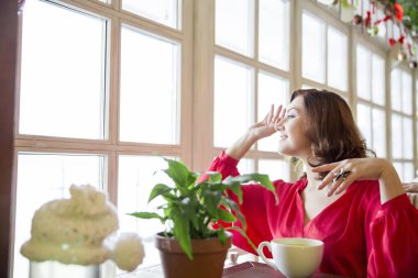 güzel genç kadın co bir masada oturan kırmızı bluz