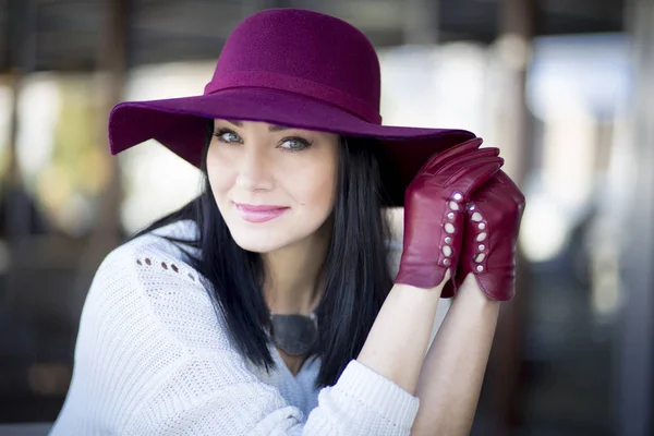 Elegante joven con hermoso maquillaje en un sombrero de color burdeos — Foto de Stock