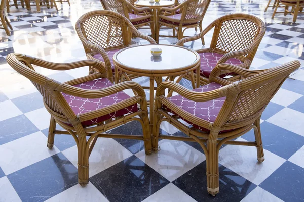 Een paar geweven van de wijnstokken van tafels en stoelen op een mozaïek marb — Stockfoto