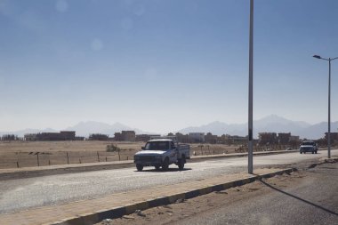 İki eski arabalar boyunca çölde ve bir s yolda ilerliyorsunuz