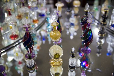 şeffaf bir tablo üzerinde birçok renkli cam şişe 