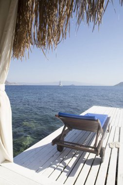Üzerinde görüntülemek bir bungalov Beyaz ahşap plaj şezlong üzerinde gelen bir 